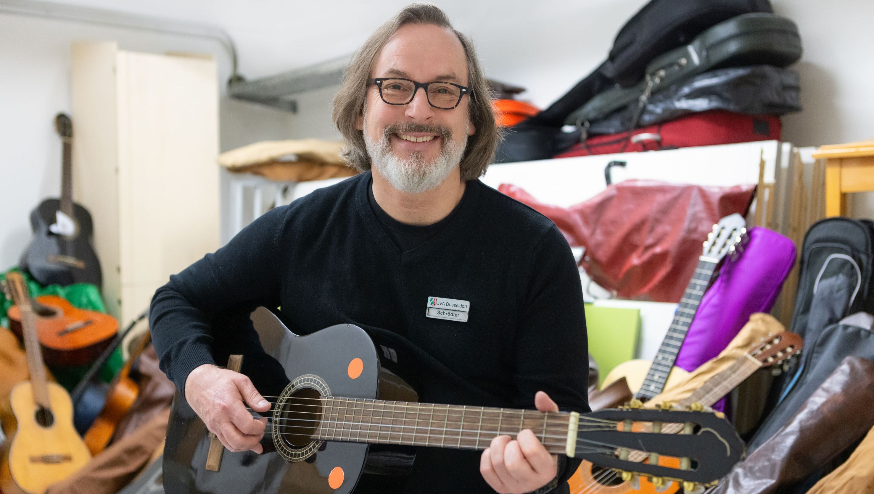Seelsorger Thomas Schrödter mit der Gitarrensammlung der Gefängnisseelsorge; Foto: Martina Chardin